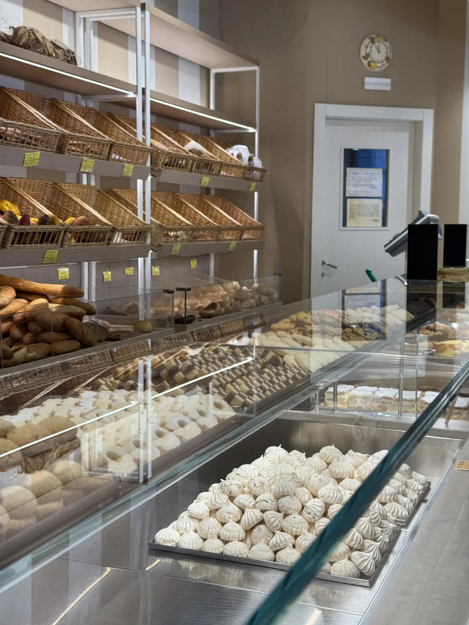 Il banco del negozio con i cesti del pane sugli scaffali e le meringhe in vetrina