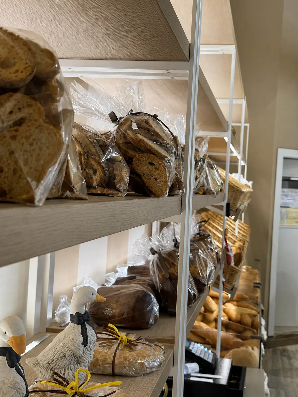 Pagnotte e pane a fette confezionati sugli scaffali di legno del negozio