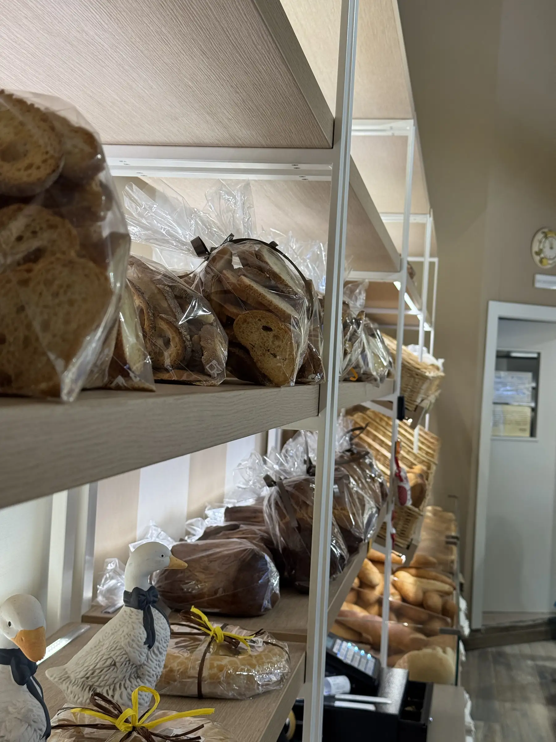 Pagnotte e pane a fette confezionati sugli scaffali di legno del negozio