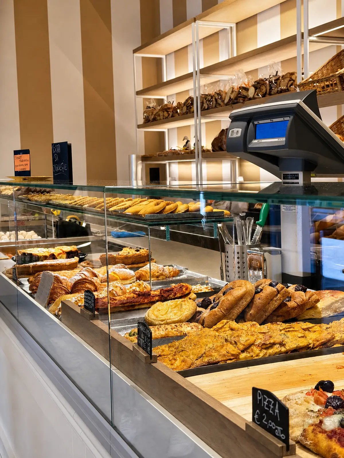 La vetrina del salato Cadenaro: pizze, focacce, strudel salati e le paste, con gli scaffali del pane sul fondo